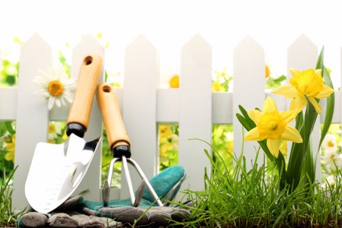 Operative wearing PPE while trimming a hedge